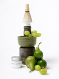 Sayaka Premium Matcha Tin mit Bambusbesen, Keramikschale und frischen Birnen und Trauben